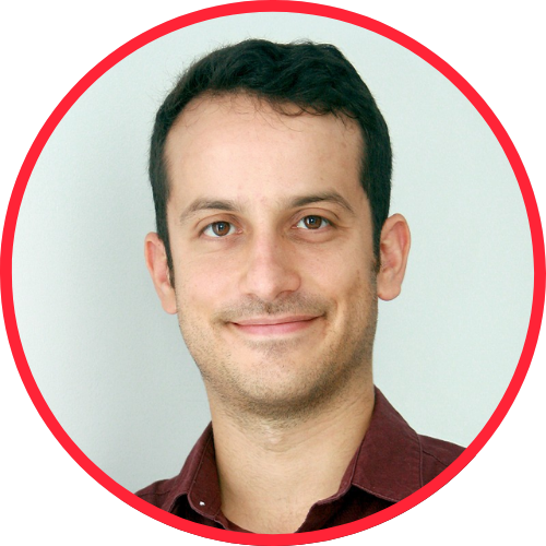 Retrato em formato circular de um homem com cabelo castanho escuro e expressão sorridente, usando camisa de cor vinho em fundo claro.